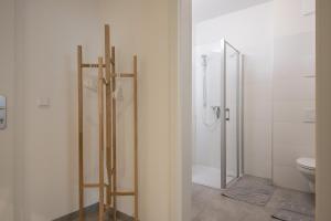 a bathroom with a toilet and a glass shower stall at City-Apartment Neubaugasse in Graz +19 photos