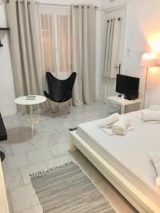 a bedroom with a bed and a table and chairs at Kyano House in Limenas