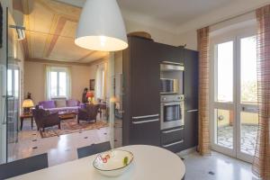 a kitchen with a table and a living room at VILLA AURORA Relax con Vista Mare e Piscina in Camogli