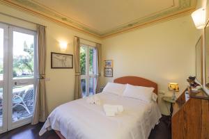 ein Schlafzimmer mit einem großen weißen Bett mit einem Fenster in der Unterkunft VILLA AURORA Relax con Vista Mare e Piscina in Camogli