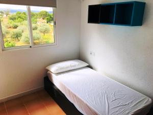 1 dormitorio pequeño con 1 cama y 2 ventanas en Apartamentos Habitat Altamar, en Alcossebre