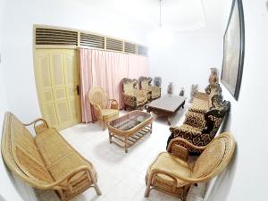 uma sala de estar com cadeiras e uma mesa em With Friends Homestay Jogja em Yogyakarta