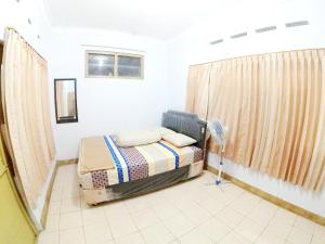 a small bedroom with a bed and a window at With Friends Homestay Jogja in Yogyakarta