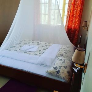 Bett mit Baldachin in einem Zimmer in der Unterkunft Rebero Kivu Resort in Kibuye
