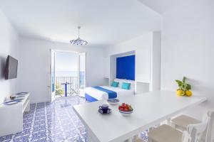 a white room with a bed and a table at Blue View Capri Apartment in Capri