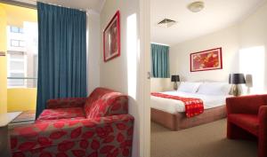 a hotel room with a bed and a chair at Chasely Apartment Hotel in Brisbane