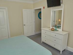 - une chambre avec un lit, une commode et un miroir dans l'établissement Atlantic Breeze Suites, à Hampton Beach