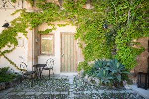 an entrance to a house with a door covered in ivy at Baglio Siciliamo Country House in Noto Marina