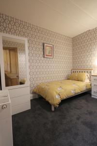 um quarto com uma cama, uma cómoda e um espelho em Arrandale em Inverness