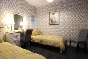 um quarto de hotel com duas camas e uma secretária e uma cama e um espelho em Arrandale em Inverness