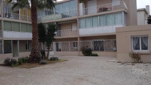 an apartment building with a palm tree in front of it at LE PATIOT 2 in Six-Fours-les-Plages