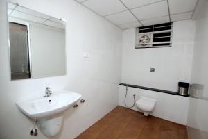 a white bathroom with a sink and a toilet at HOTEL SHRINGAR PALACE in Hubli