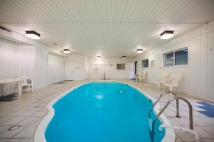 a large indoor pool with blue water in a building at Ramada by Wyndham Effingham in Effingham