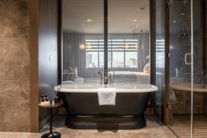 a bathroom with a bath tub and a shower at Dakota Manchester in Manchester +64 photos