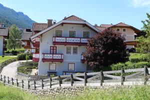 une maison blanche avec une clôture devant elle dans l'établissement Casa Azzurra, à Pozza di Fassa