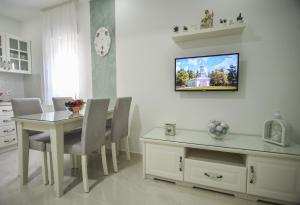 a dining room with a table and a television on the wall at Gloria Apartments 2 in Međugorje +61 photos