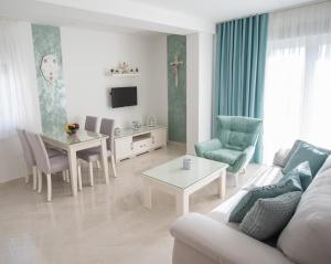 a living room with a couch and a table and chairs at Gloria Apartments 2 in Međugorje