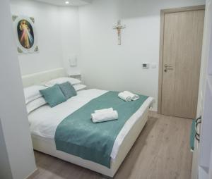 a bedroom with a bed with towels on it at Gloria Apartments 2 in Međugorje