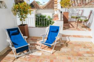 two blue chairs on the patio of a house at São Paulo Boutique Hotel - SPBH in Tavira