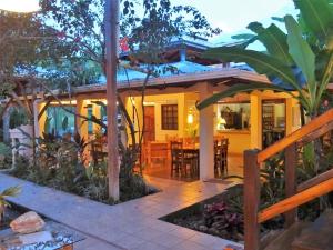 ein Haus mit einer Terrasse und einem Essbereich in der Unterkunft Hotel Pura Vida in Puerto Viejo