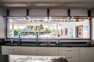 a kitchen with a sink and a large mirror at Boca Gentil villa C3 - Jan Thiel in Willemstad