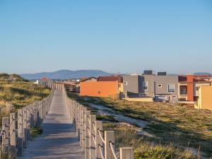 a boardwalk leading down to a beach with buildings at Barranha Beach House in Aguçadoura