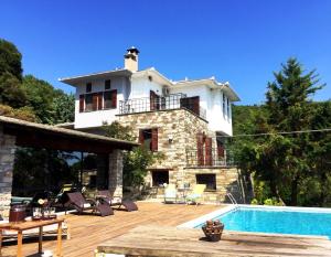 a villa with a swimming pool and a house at Art Luxury Resort Villa in Áyios Vlásios