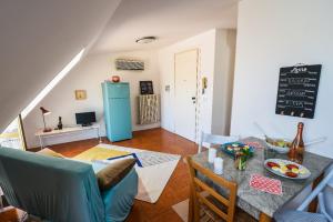 a living room with a table and a blue refrigerator at LA MANSARDINA VINTAGE in San Benedetto del Tronto