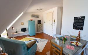 a living room with a table and a blue refrigerator at LA MANSARDINA VINTAGE in San Benedetto del Tronto +9 photos