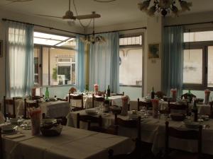 a dining room with tables and chairs with white table cloth at Hotel Aquilia in Laigueglia