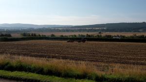 un grand champ avec un tracteur au milieu dans l'établissement Anick Grange Farm B&B, à Hexham