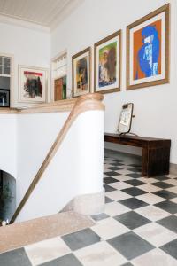 a room with a checkered floor and art on the walls at São Paulo Boutique Hotel - SPBH in Tavira