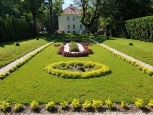 a garden with a circle of flowers in the grass at Pałac Nakomiady in Nakomiady