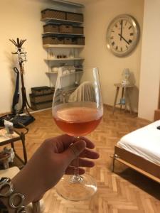 a person holding a glass of wine in a room at Apartment Vintige in Cluj-Napoca