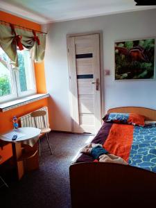 a bedroom with a bed and a table and a window at Noclegi i Restauracja Gracja in Bełchatów