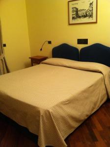 ペルージャにあるHotel il Cignoのベッドルーム(ベッド1台、テーブル、ランプ付)