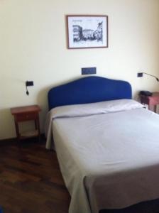 a bedroom with a bed with a blue head board at Hotel il Cigno in Perugia