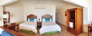 a large bedroom with two beds and a table at Punta Pescadero Paradise Hotel & Villas in Los Barriles