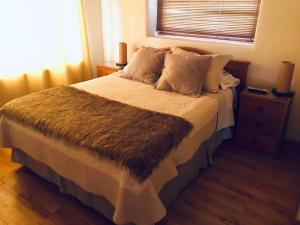 1 dormitorio con 1 cama grande con manta marrón en El damascal Paihuano, en Paihuano