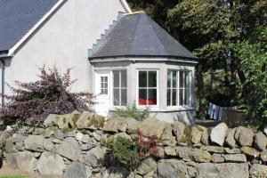 ein Haus mit einem Fenster und einer Steinmauer in der Unterkunft Roualeyn in Huntly