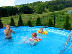 two children swimming in a swimming pool at Orlikowe Wzgórze in Rabe