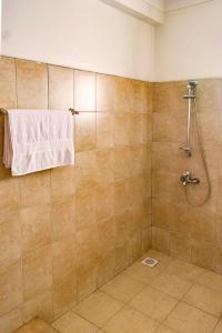 a bathroom with a shower with a towel on the wall at Reinah Tourist Hotel Fort Portal in Fort Portal
