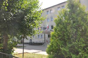 a building with a flag in front of it at Krechowiak in Augustów