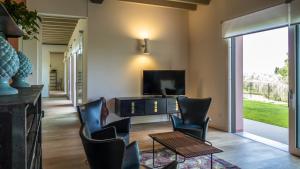 een woonkamer met stoelen en een televisie en een tafel bij Villa Collivo in Lazise