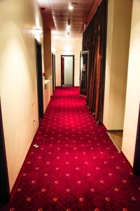 a long red carpeted hallway with a red carpet at Hotel Grand in Zugdidi