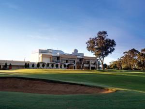 um campo de golfe com um verde e um edifício em Rich River Golf Club em Moama