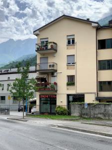 ein großes Gebäude mit Balkonen an der Straßenseite in der Unterkunft Appartamento Stelvio in Morbegno
