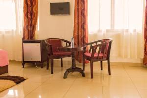 a table and chairs in a room with a window at Reinah Tourist Hotel Fort Portal in Fort Portal
