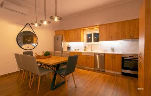 eine Küche mit einem Holztisch und Stühlen sowie ein Esszimmer in der Unterkunft Bitsakis Family I - Paleochora Luxury House in Palaiochóra