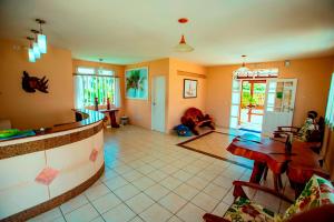 a living room with a table and a dining room at Brisamar Hotel Pousada in Barra de São Miguel